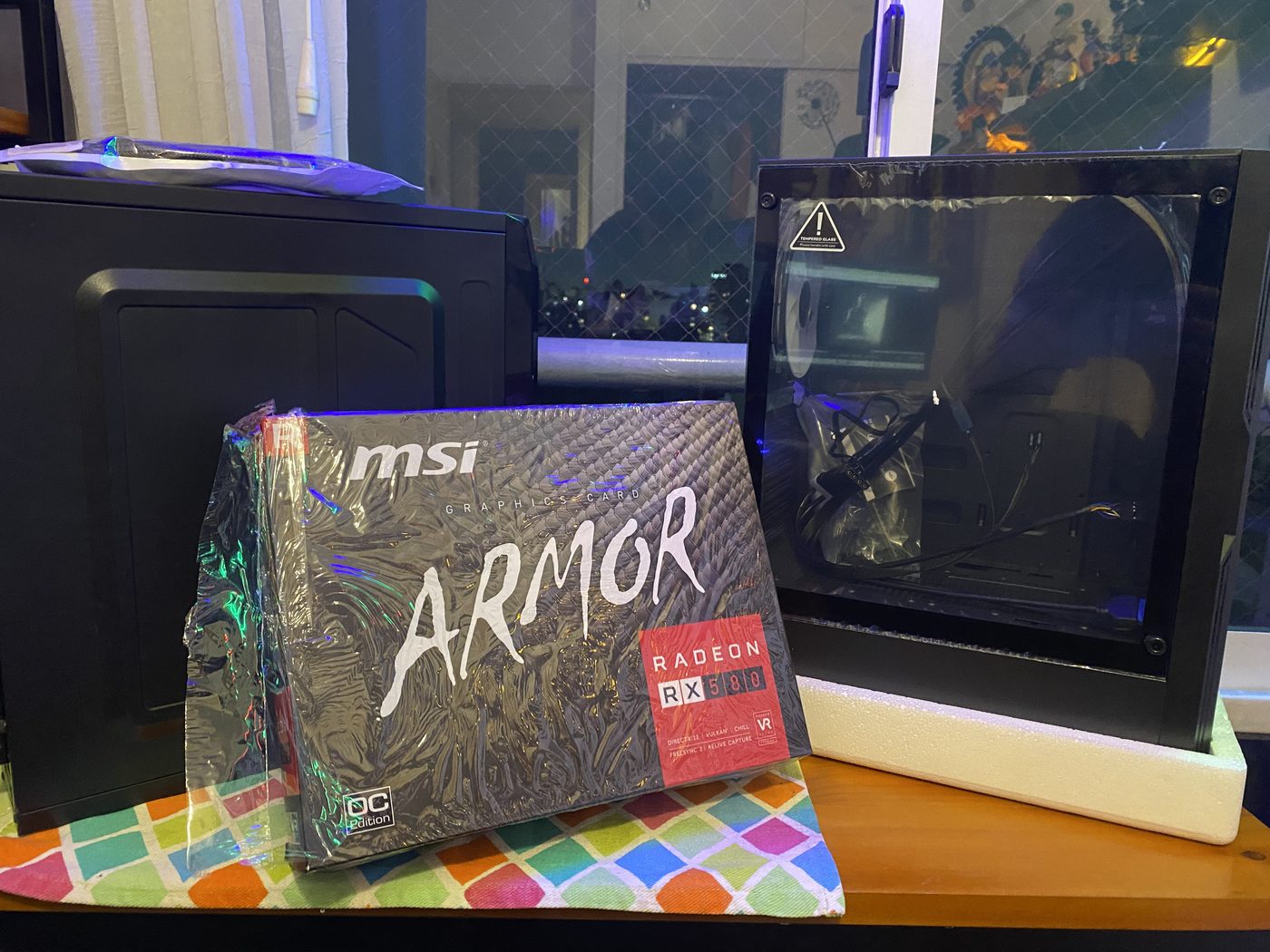 PC armada con la iluminación encendida, junto a la caja de la placa de video
